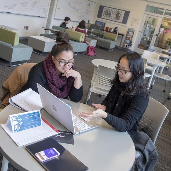 Two students consider a laptop